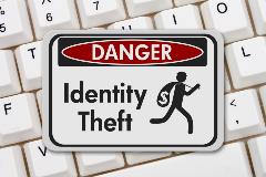 Id Theft sign laying on top of keyboard