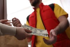 Man delivering food in exchange for money.