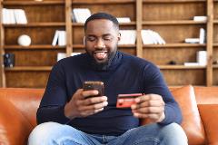 Happy man shopping online on cell phone.